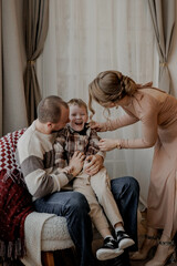 Naklejka premium Family parents with young son at home having fun and laughing