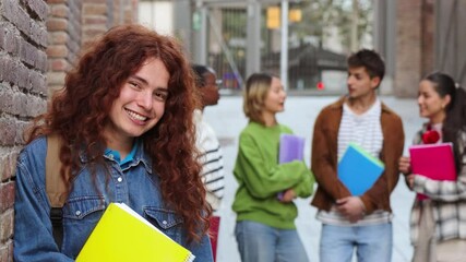 Energetic student with curly hair confidently standing among diverse group of classmates in vibrant urban campus environment, showcasing camaraderie and community within academic setting