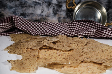 Tarhana cips, crispy snacks a traditional turkish anatolian fermented soup base made into crunchy chips made of youghurt and cereals, served with brass kitchenwear