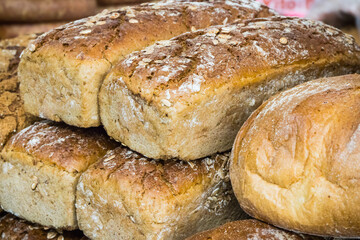 Fresh traditional loaves of wheat or rye bread on stall or in bakery