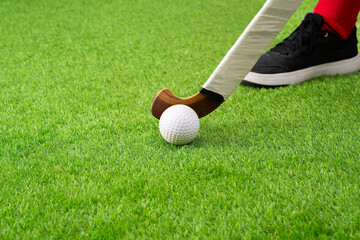 Close-up of hockey player, stick and ball on artificial turf and copy space.