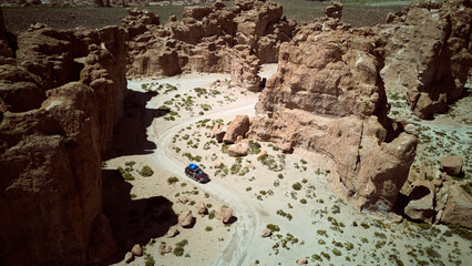 Curved Sand Road with a Car in the Canyon