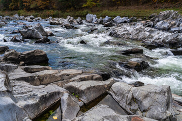 rocks and flowing stream in the autumn valley