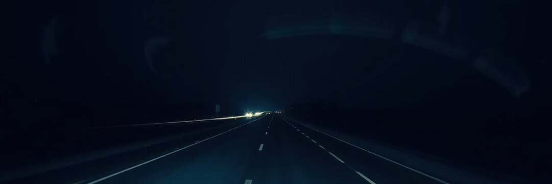 Desolate highway stretching into the darkness of night, towering buildings, sci-fi cityscape