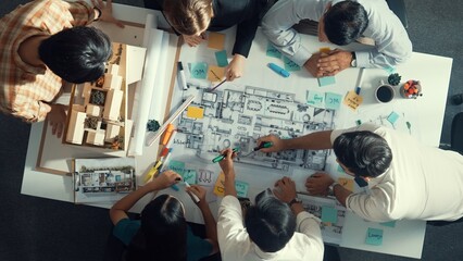 Top aerial view of project manager or civil engineer writing at blueprint and planning building...