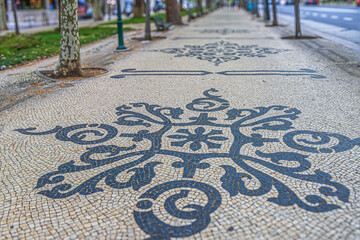 Avenida da Liberdade, Lisbon, Portugal, famous for its mosaic decorated sidewalks, known as “calçada portuguesa,” made of black and white limestone. The patterns is geometric shapes with floral motifs