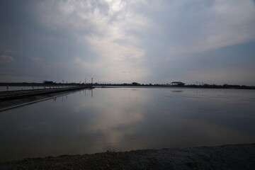 Tranquil sunset reflection over serene waterbody coastal area nature scene calm environment wide angle peaceful vibes