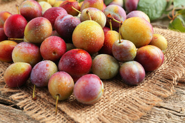 Pile of tasty ripe plums on table, closeup