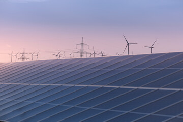 Solaranlage und Windräder bei Sonnenuntergang