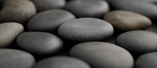 Smooth black stones laid out on a surface for natural decor purposes
