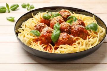 Delicious pasta with meatballs on wooden table, closeup