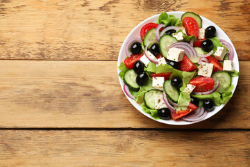 Delicious salad with feta cheese on wooden table, top view. Space for text