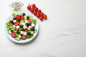 Delicious salad with feta cheese served on white marble table, top view. Space for text