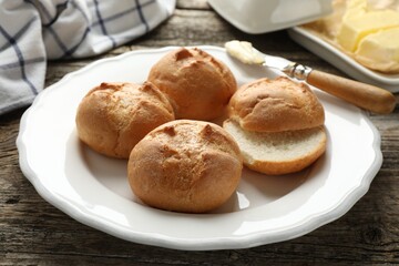 Plate with homemade tasty buns on wooden table, closeup