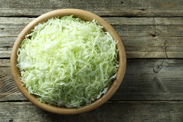 Fresh shredded cabbage on wooden table, top view