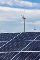 Solaranlage und Windrad bei wolkigem Himmel