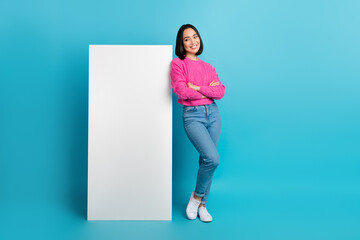 Full size portrait of indonesian pretty girl folded hands look empty space telephone display isolated on blue color background