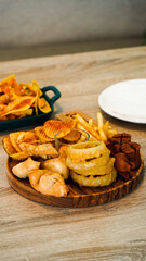 Side dishes menu at a cafe containing French fries, chicken wings, sausages, onion rings, and nacos