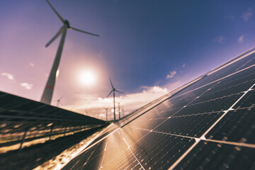 Solaranlage und Windräder bei Sonnenuntergang
