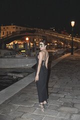 Naklejka premium Woman with carnival mask night view of ponte degli scalzi in Venice, Italy.
