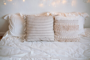 Cozy bedroom with soft pillows and fairy lights in a restful atmosphere