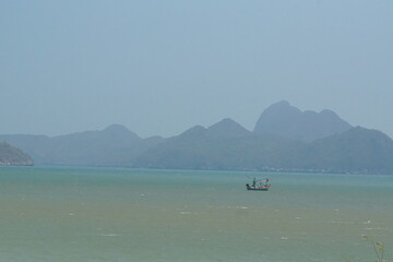 Fishing boat navigating tranquil waters coastal landscape scenic viewpoint serene nature ocean mood