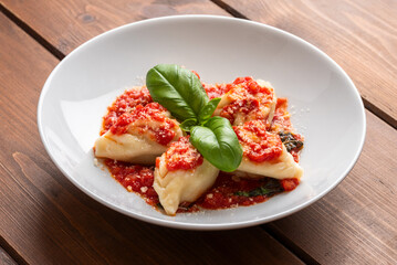 Culurgionis ripieni di patate, pecorino e menta e conditi con sugo, classica ricetta di pasta della cucina Sarda cibo italiano 