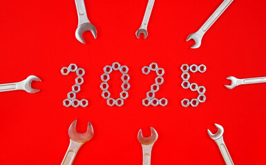 Year 2025. The number 2025 is made of metal nuts and keys on a red background.
