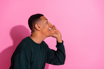 Photo of handsome good mood guy wear sweatshirt arm mouth screaming emtpy space isolated pink color...
