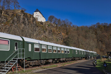 Obraz premium Historische Eisenbahnwaggons des Zughotels am Fuße des Schlosses Wolkenstein im Zschopautal, Wolkenstein, Erzgebirgskreis, Sachsen, Deutschland