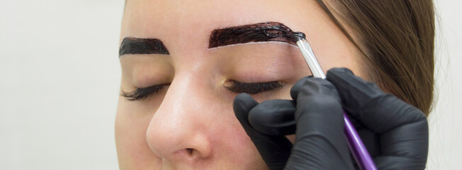 Eyebrow tinting.Cosmetic procedures.Eyebrow makeup in beauty salon by professional.Close up.