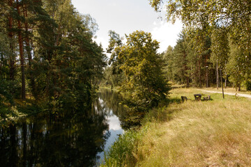leniwa rzeka wśr&oacute;d drzew w pobliżu łąka