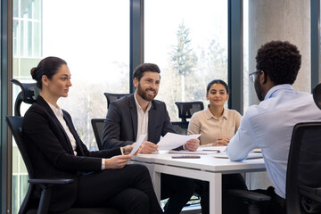 Corporate team engaged in business meeting around office table. Professionals discussing project strategy with focus on collaboration. Teamwork and leadership in modern office environment.