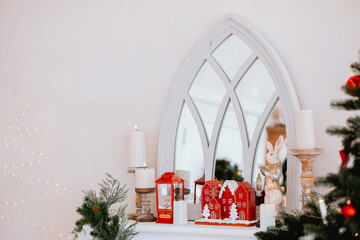 Cozy holiday decor featuring a mirror and festive decorations by the fireplace