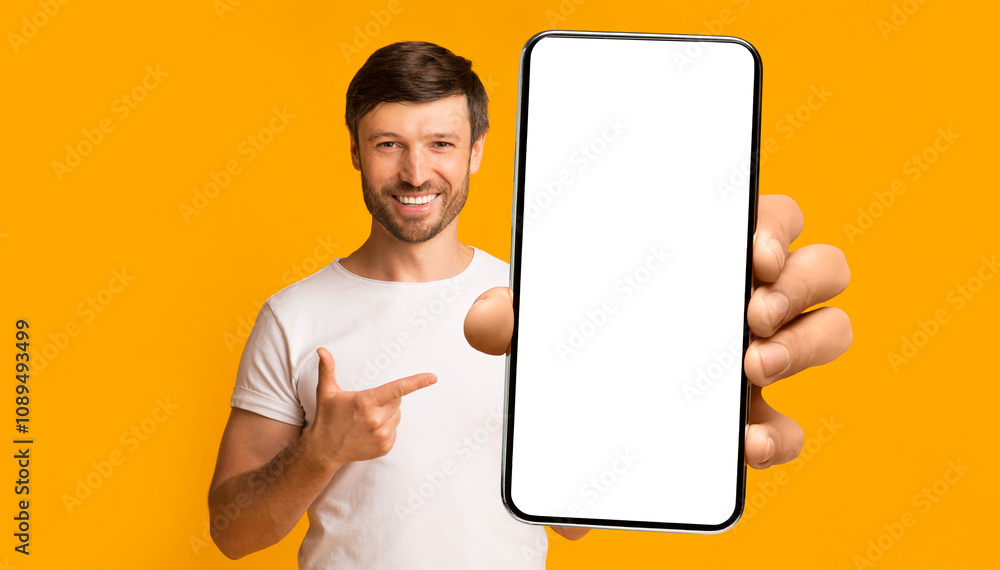 Poster recommendation. portrait of excited bearded man holding big smartphone with white blank screen in ha