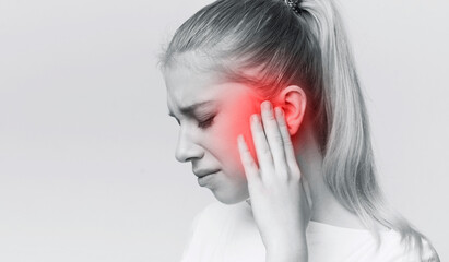 Young woman with sore ear, suffering from otitis, black and white panorama with red accent, free...