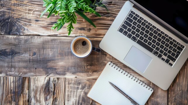 Work from home. desk office with laptop, blank notepad, coffee cup and pen on wood table. Flat lay top view copy space.