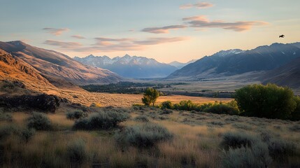 Obraz premium Stunning sunset over rugged mountains and open fields in a serene landscape.