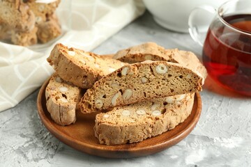 Traditional Italian almond biscuits (Cantucci) on grey textured table, closeup