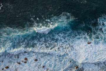 Blue ocean wave on yellow sandy beach. Sea waves and sand the summer background. Summer seascape beautiful waves, blue sea water. Top view from drone. Sea aerial view, tropical nature background.
