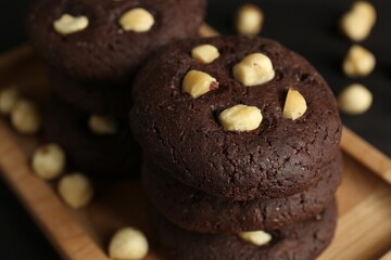 Delicious chocolate cookies with hazelnuts on table, closeup