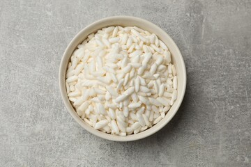 Puffed rice in bowl on light grey table, top view