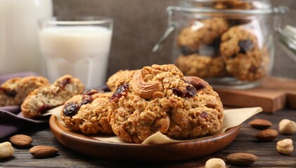 Delicious oatmeal cookies with raisins and nuts served on wooden table, closeup