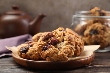 Delicious oatmeal cookies with raisins and nuts on wooden table, closeup