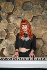 Beautiful red-haired keyboardist woman performing confidently