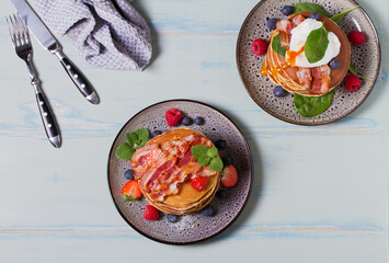 Stack of pancakes  with savory topping and berries at breakfast. View from above, top studio shot