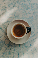 Cup of black coffee on a table in a cafe. Top view.