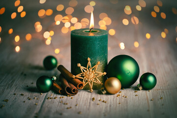 Green Christmas Candle on 1 . Advent with classic natural Xmas decoration with balls and cinnamon...