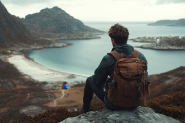Fototapeta premium A person sits on a rocky ledge, overlooking a serene coastal landscape.