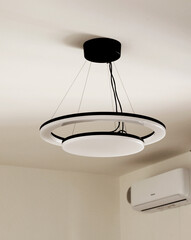 LED white bulb black wires on ceiling in room. Lighting and energy saving. Modern minimalist design. 